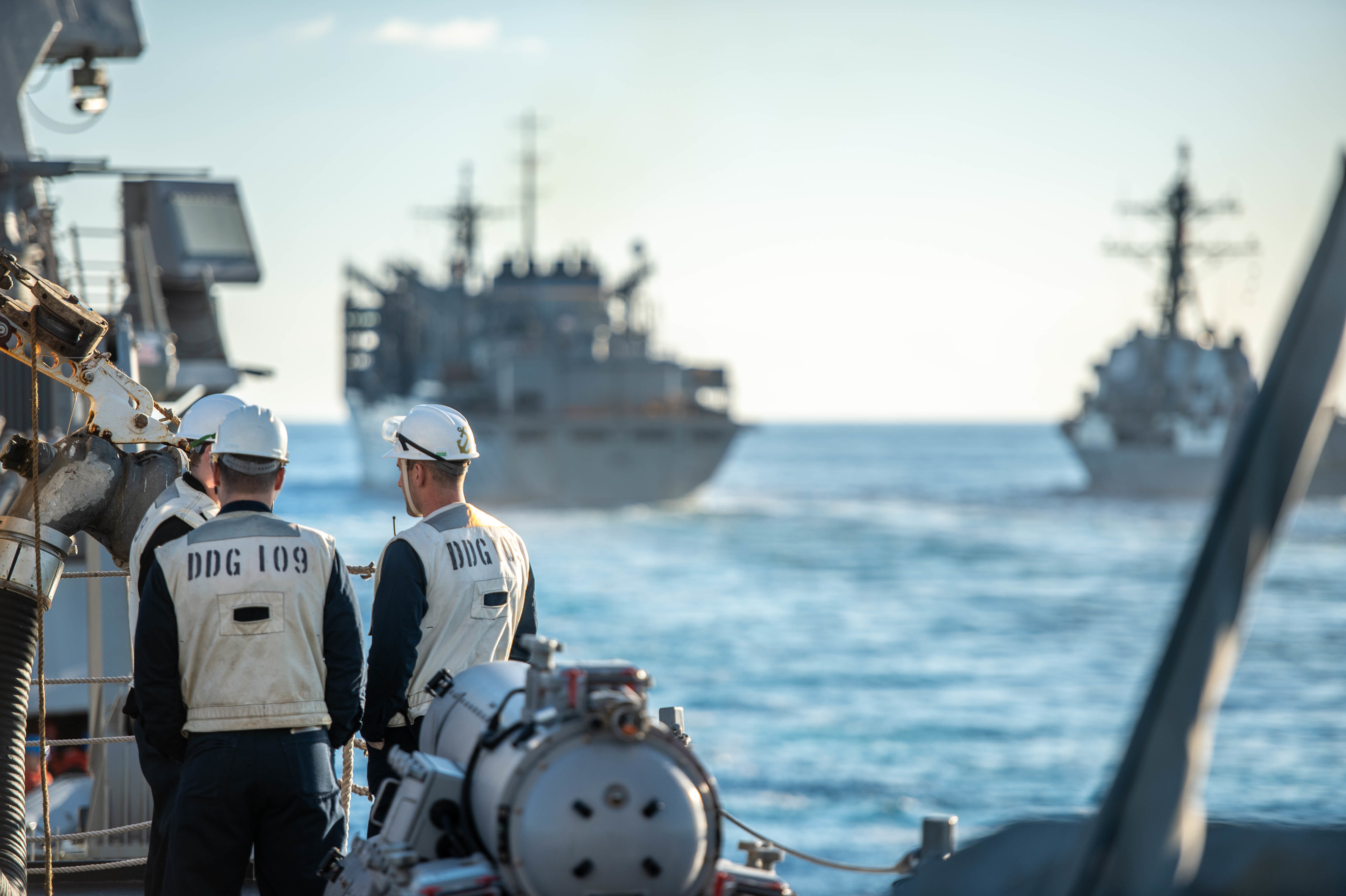 The Arleigh Burke-class guided-missile destroyer USS Jason Dunham (DDG 109) approaches the Supply-class fast combat support ship USNS Supply (T-AOE-6) and the Arleigh Burke-class guided-missile destroyer USS Bainbridge (DDG) during a replenishment-at-sea.