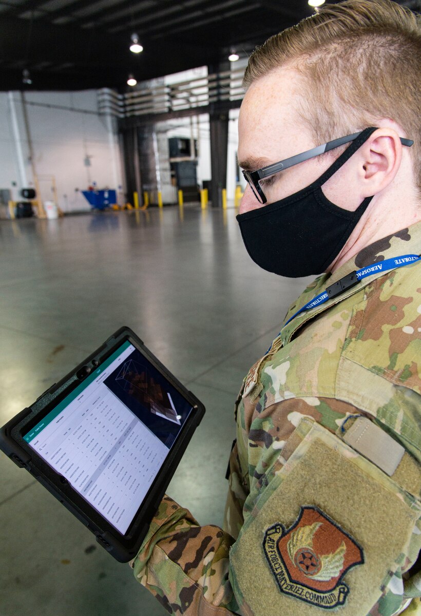 Capt. Christian Potts, Air Force Research Laboratory autonomous control engineer, reads processed cargo information scanned by the Configured Air Load Building Tool during testing on Dover Air Force Base, Delaware, Nov. 18, 2021. In an effort to modernize the 2T2 career field as part of the Aerial Port of the Future initiative, the 436th Aerial Port Squadron was selected for CALBT testing due to its location and daily cargo movement. (U.S. Air Force photo by Roland Balik)