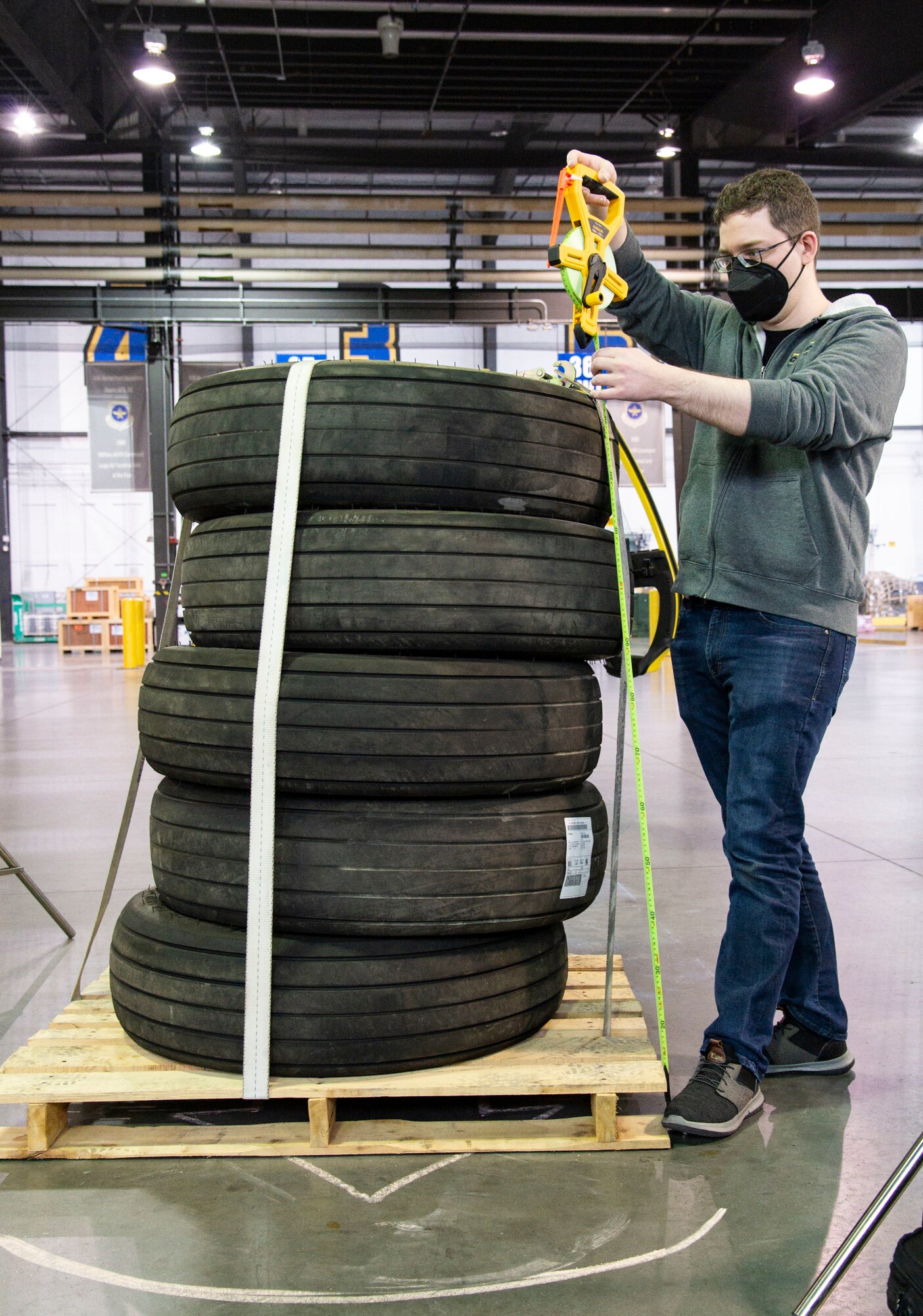 Vassili Koriabine, Cougaar Software Inc. software engineer, measures the total height of five tires on a pallet during Configured Air Load Building Tool testing on Dover Air Force Base, Delaware, Nov. 17, 2021. In an effort to modernize the 2T2 career field as part of the Aerial Port of the Future initiative, the 436th Aerial Port Squadron was selected for CALBT testing due to its location and daily cargo movement. (U.S. Air Force photo by Roland Balik)
