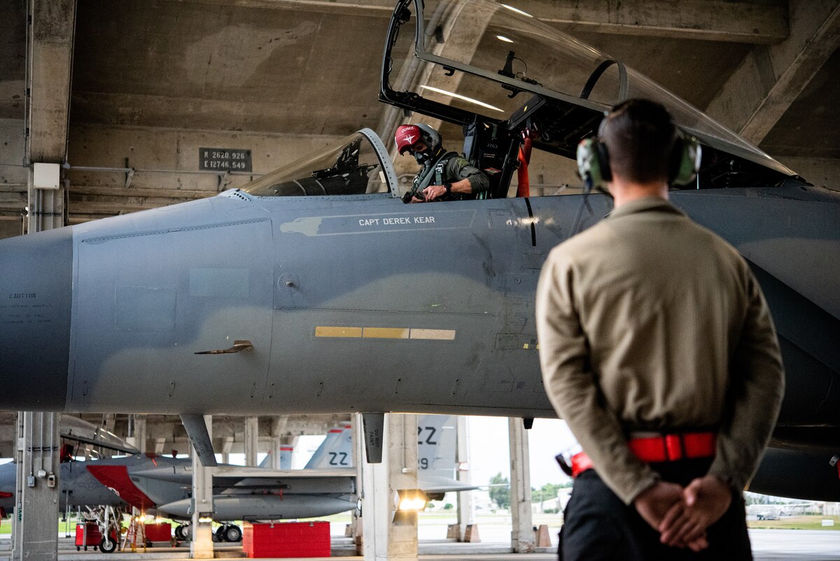 A U.S. Air Force pilot from the 67th Fighter Squadron, left, communicates with Airman 1st Class Rafael De Leon, right, 67th Aircraft Maintenance Unit crew chief, via headset before takeoff during exercise Southern Beach 22-2 at Kadena Air Base, Japan, Jan. 19, 2022. While conducting preflight checks, communication between the pilot and crew chief ensures safety and awareness during aircraft operations. (U.S. Air Force photo by Airman 1st Class Sebastian Romawac)