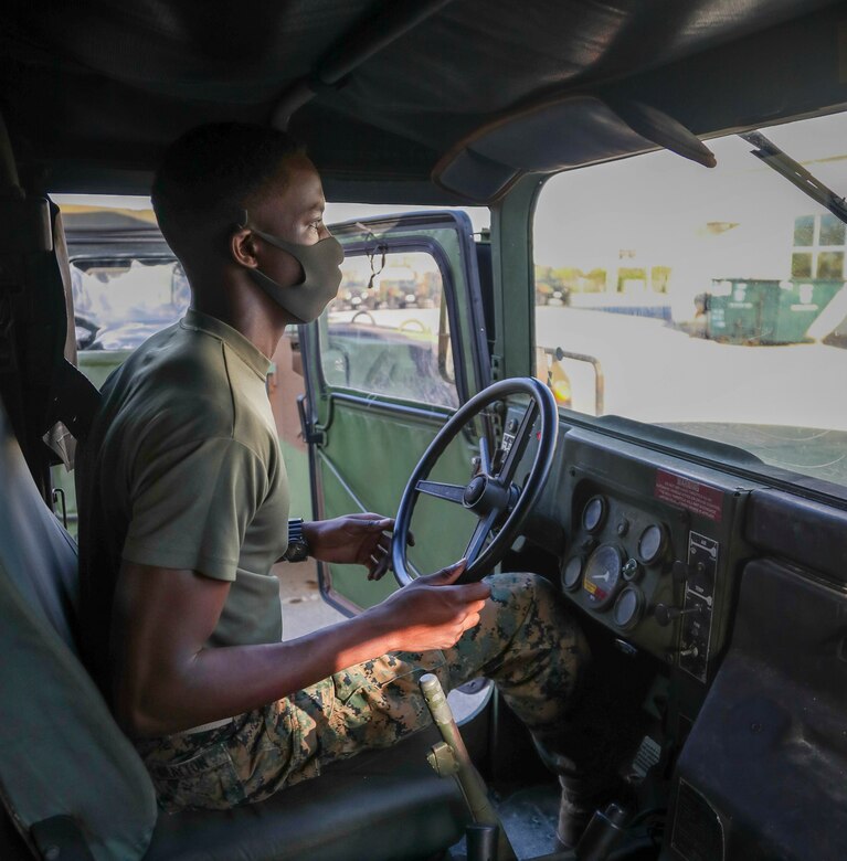 U.S. Marine Corps Pfc. Benjamin Crayton, a motor vehicle operator with Headquarters and Support Battalion, Marine Corps Installations Pacific, follows hand and arm signals during an inspection of a Humvee on Camp Foster, Okinawa, Japan, Jan. 10, 2022. Crayton was born in Monrovia, Liberia during the First Liberian Civil War, and immigrated to Europe as a refugee. When he was 17 years old he moved to the U.S. and in 2021 he enlisted in the Marine Corps. (U.S. Marine Corps photo by Lance Cpl. Jonathan Beauchamp)