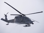 An Alaska Air National Guard 210th Rescue Squadron HH-60G Pave Hawk transits Joint Base Elmendorf-Richardson's Malamute Drop Zone Feb. 10, 2021, during parachute jump operations.