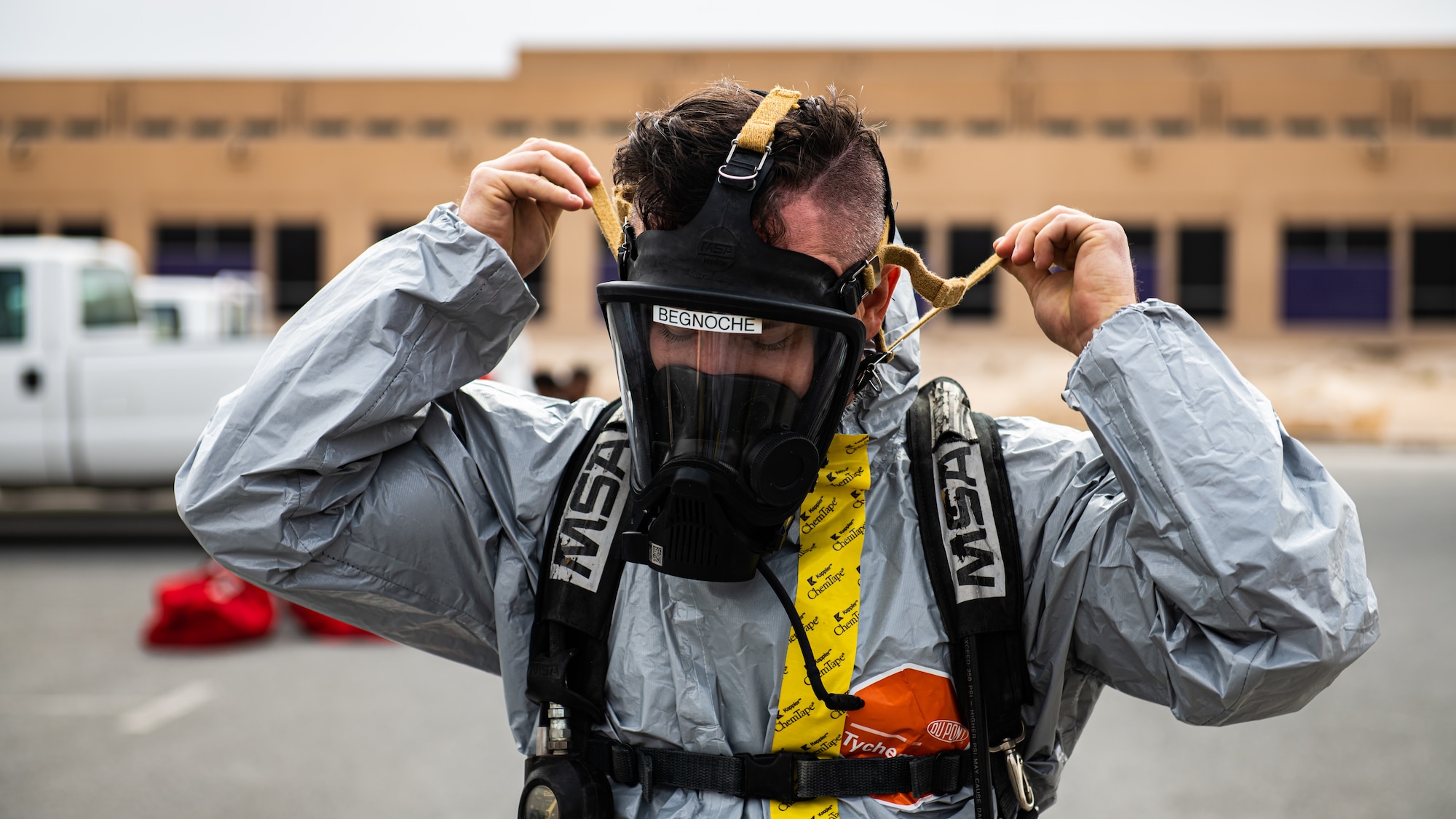 Airman puts on gas mask.