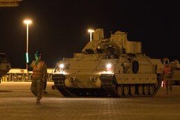 a Soldier directs an M2 Bradley