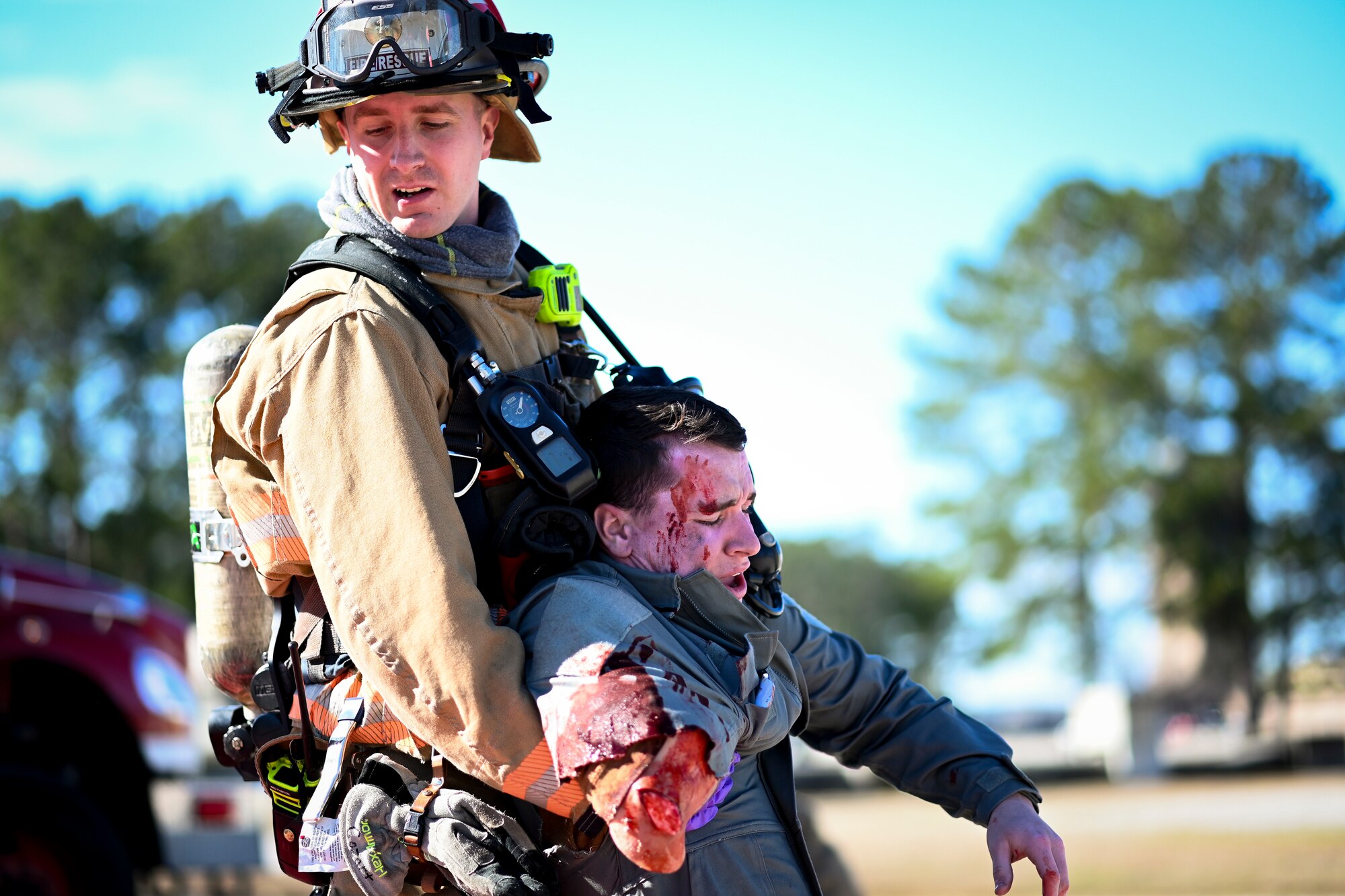 U.S. Air Force Staff Sgt. Andrew Cozart, 20th Civil Engineer Squadron lead firefighter, carries an injured volunteer over to the triage area during a mass casualty training exercise at Shaw Air Force Base, South Carolina, Jan. 19, 2022. The purpose of the exercise was to enhance and build on each agency's readiness capabilities for quick response emergencies. (U.S. Air Force photo by Senior Airman Madeline Herzog)