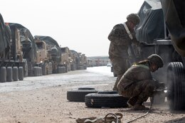 Soldier works on truck in convoy
