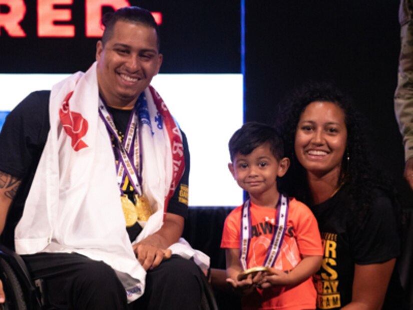 U.S. Army retired Staff Sgt. Joel Rodriguez poses with his with wife Liannie and son Elijah after receiving his medals