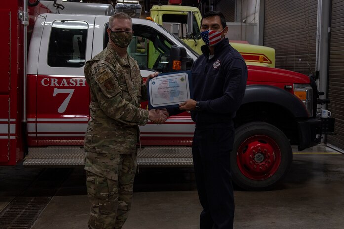 U.S. Air Force Col. David Vanderburg, 97th Mission Support Group commander, poses with Staff Sgt. Ryan Mayher, 97th Civil Engineer Squadron Fire and Emergency Services firefighter, at Altus Air Force Base, Jan. 13, 2022. Mayher was honored for his efforts in saving the life of a 78-year-old individual. (U.S. Air Force photo by Airman 1st Class Miyah Gray)