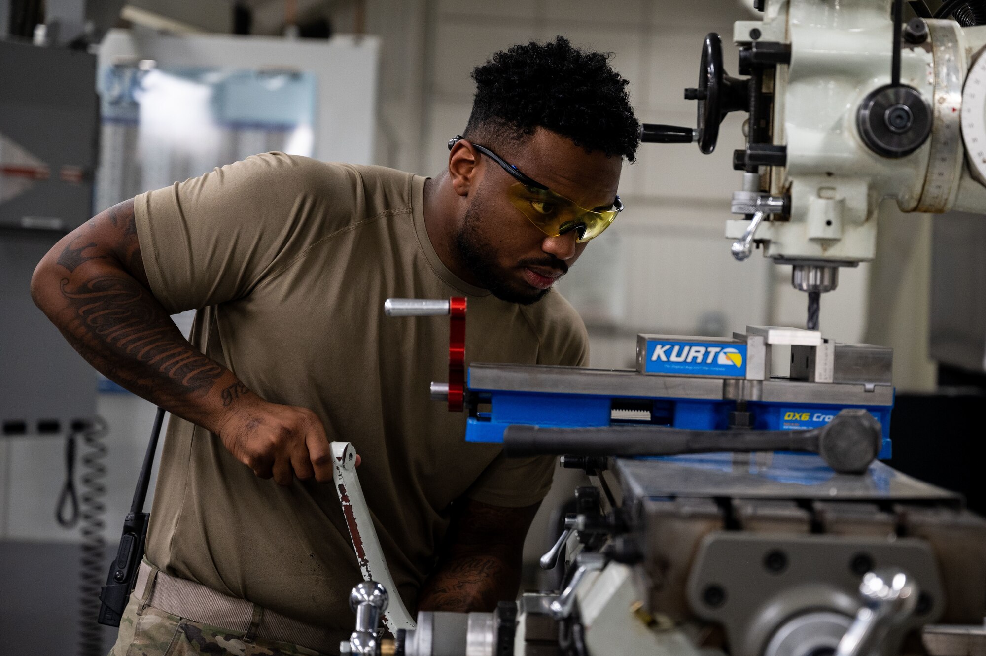 A metals tech operates a machine.