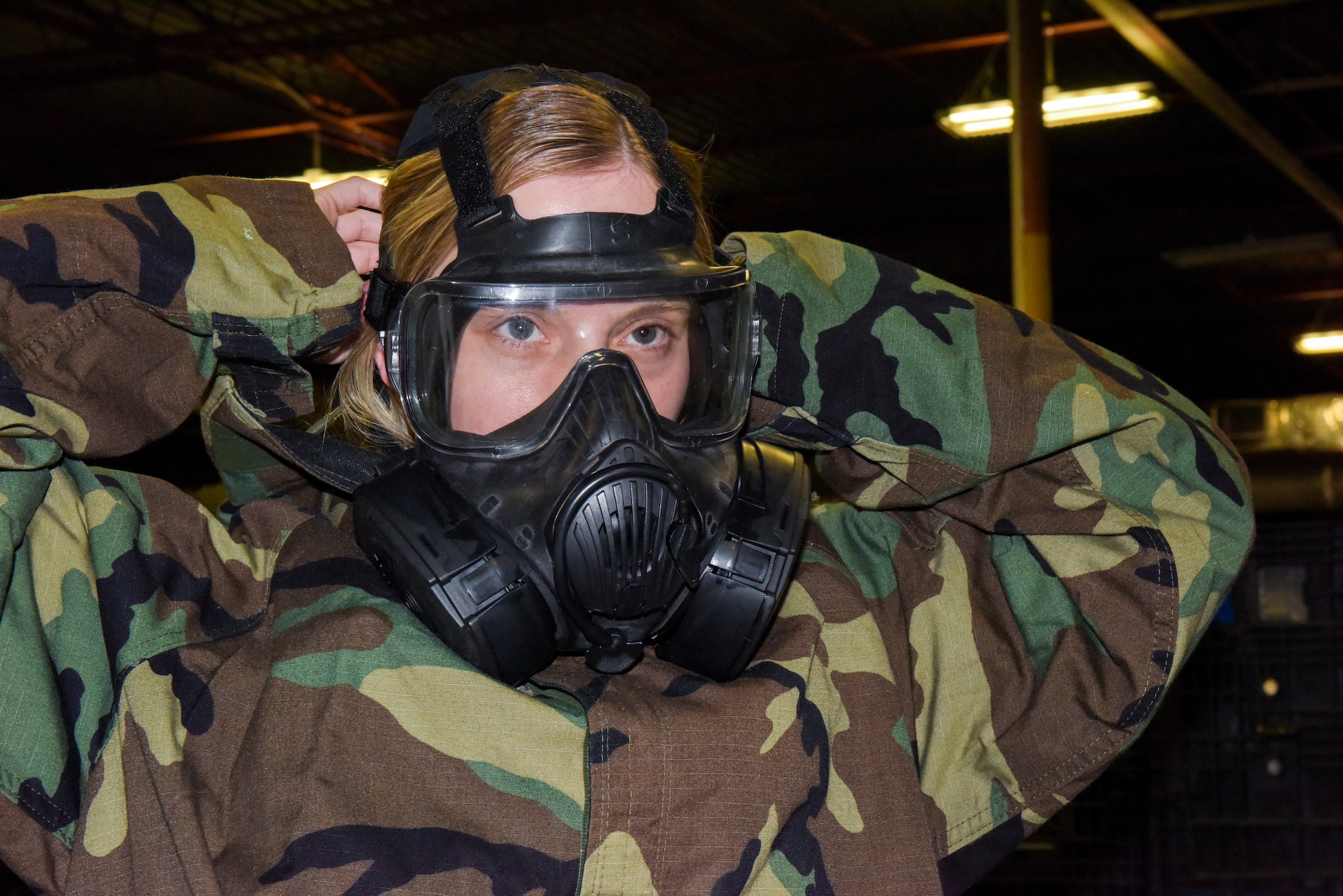 U.S. Air Force Senior Airman Paige Carver, a 6th Logistics Readiness Squadron Individual Protective Equipment (IPE) technician, tries on mission oriented protective posture gear at MacDill Air Force Base, Florida, Jan. 18, 2022.