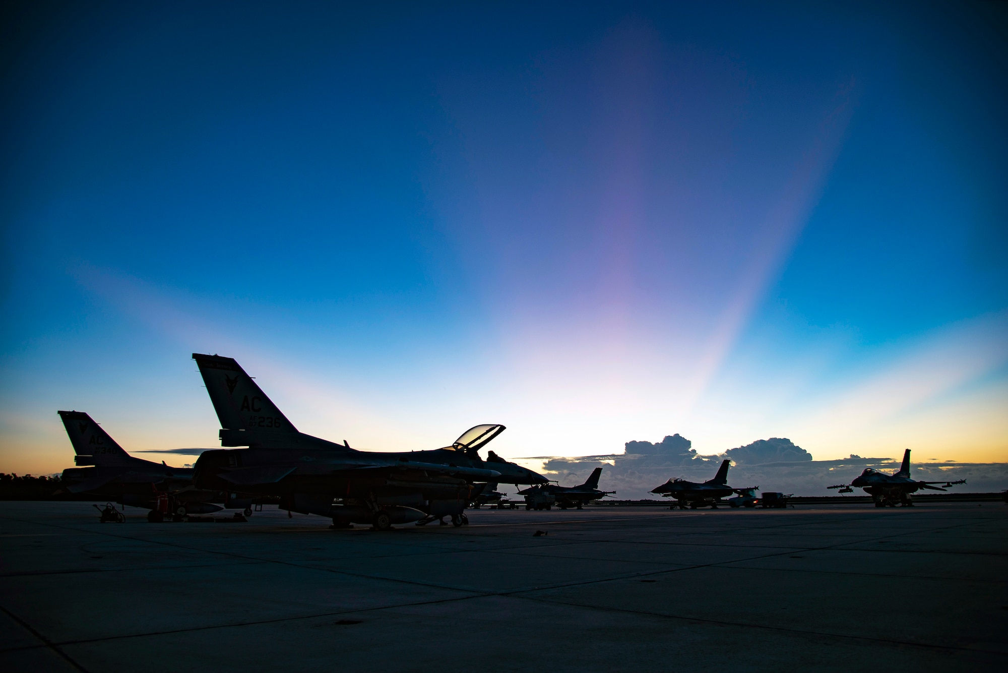 F-16C Fighting Falcons from the New Jersey Air National Guard’s 177th Fighter Wing are illuminated by morning sunlight on the flightline