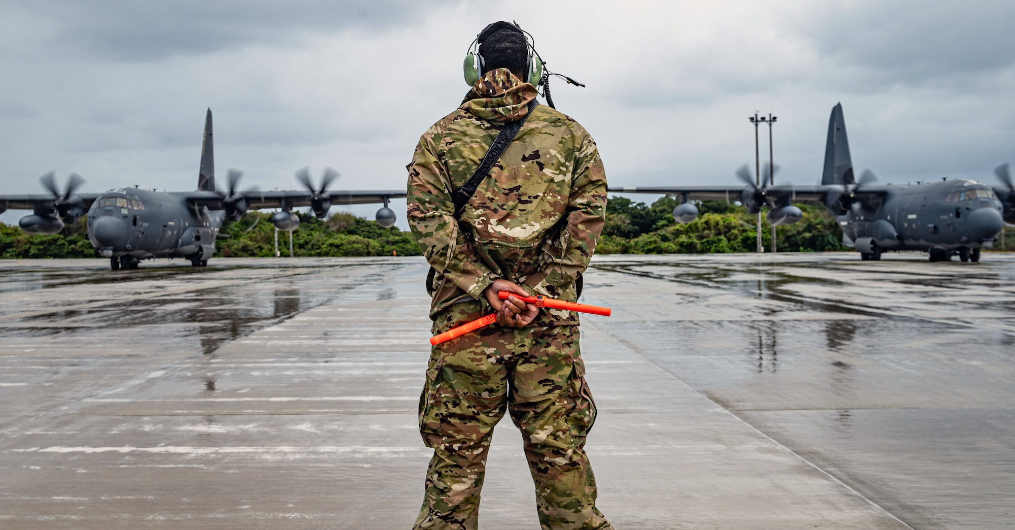 A U.S. Air Force Airman assigned to the 353rd Special Operations Aircraft Maintenance Squadron prepares to marshall an MC-130J Commando II