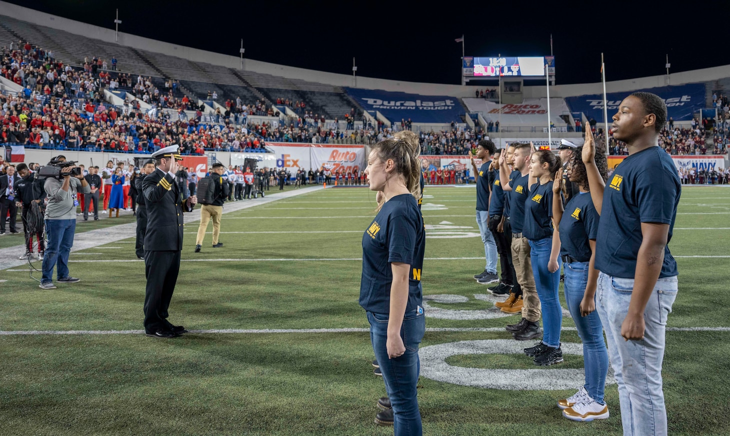 Cmdr. John Culpepper leads future Sailors in the oath of enlistment before the 2021 Liberty Bowl.