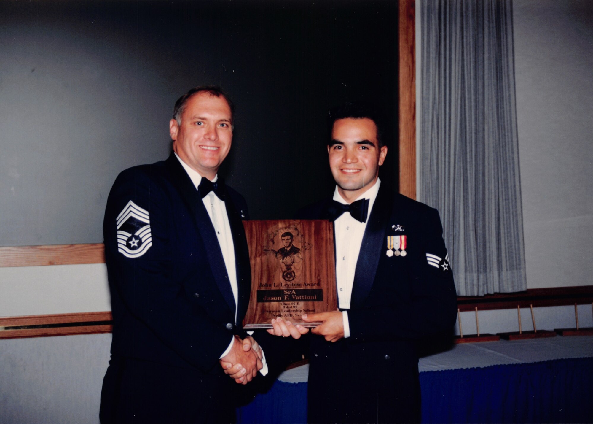 photo of two Airmen standing next to each other with an award between the two