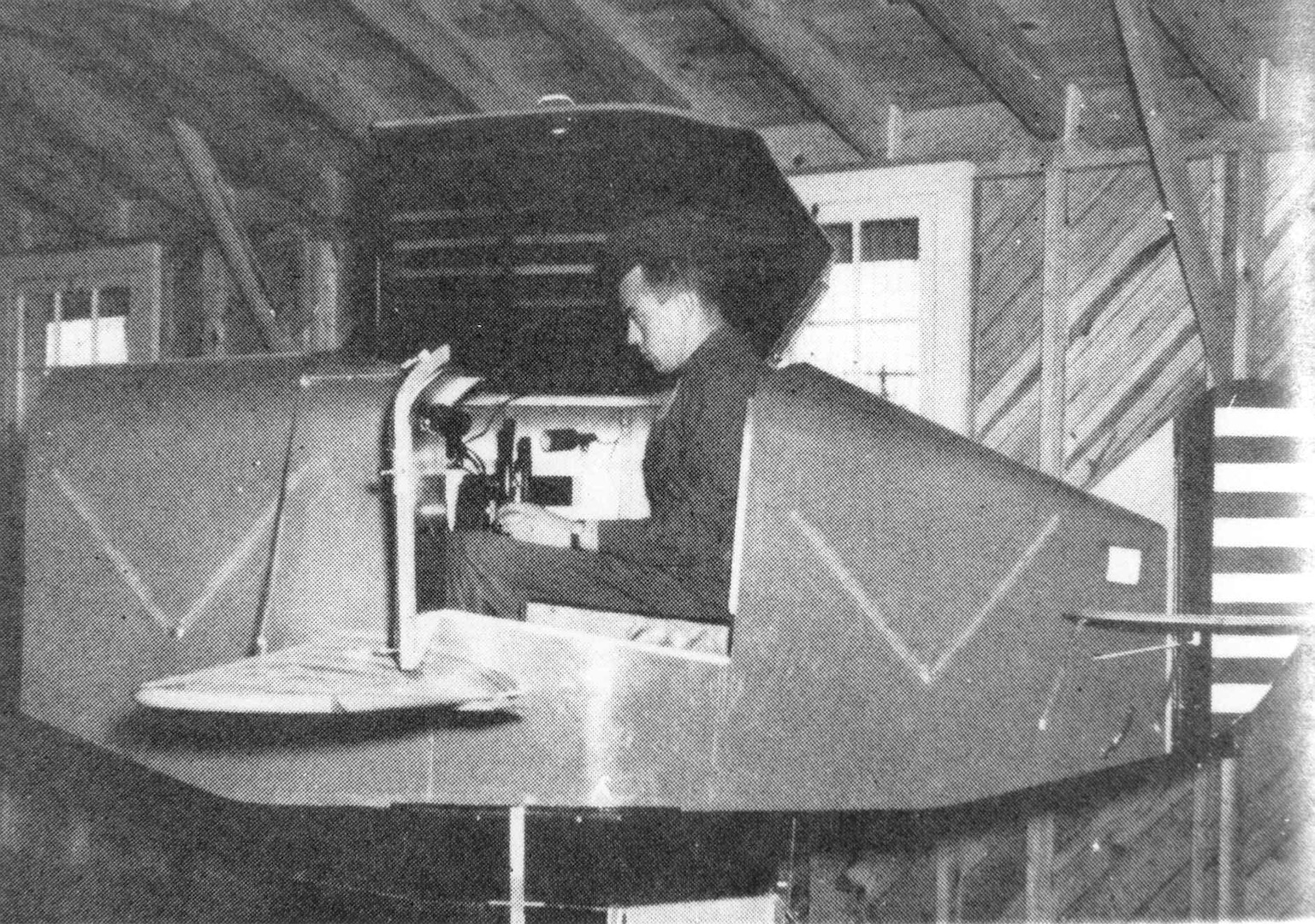 A student during the World War II era uses a Link Trainer, an early type of flight simulator