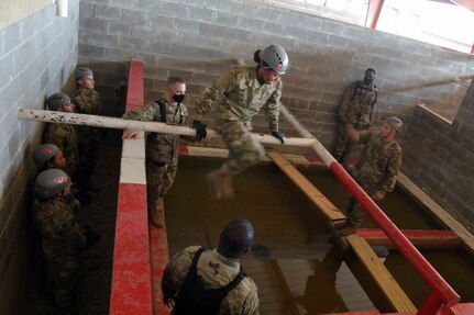 Air Force Officer Training School cadets work together to solve obstacle