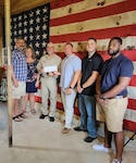 people stand in front of a US flag