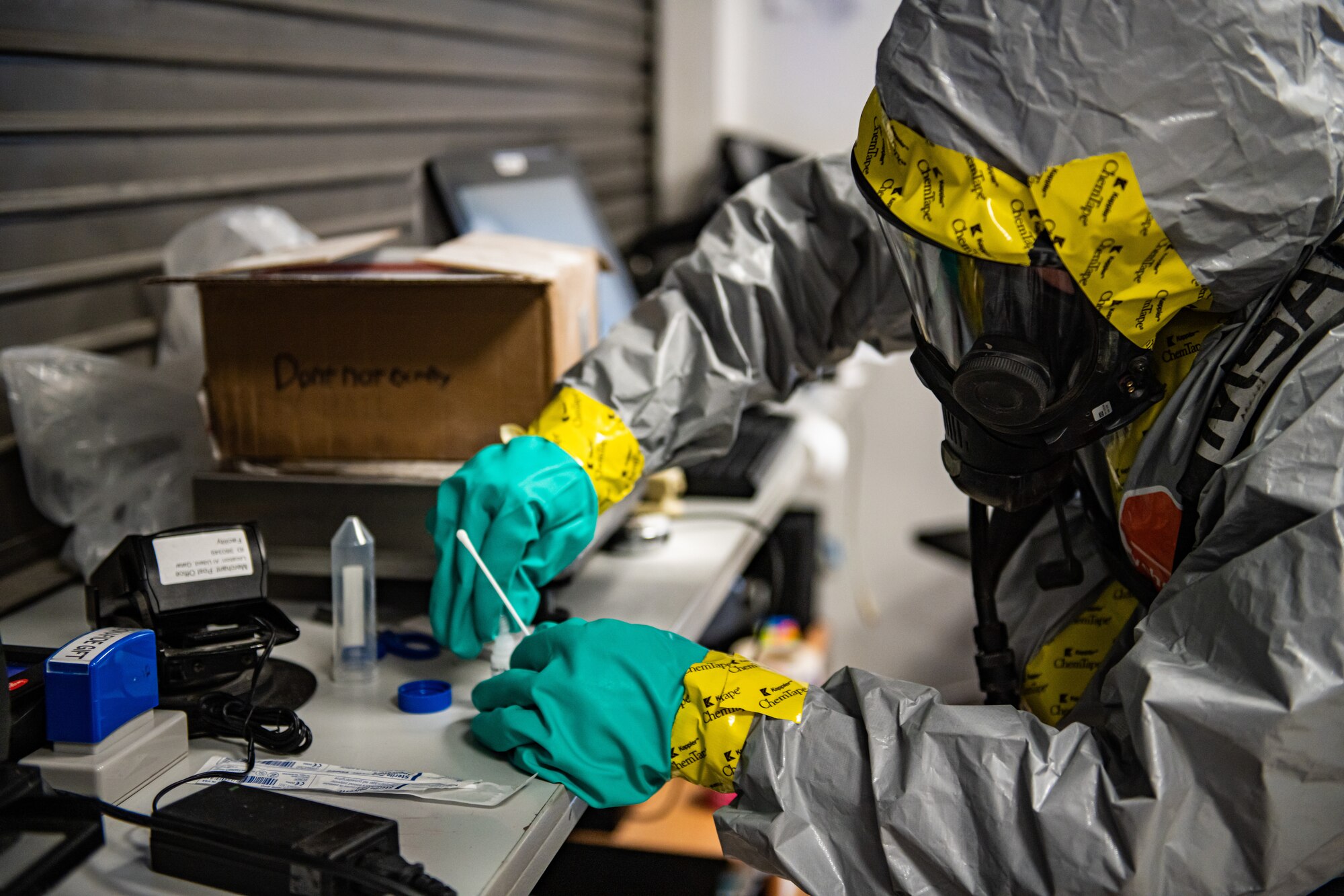 Airman collects samples from a suspicious package.