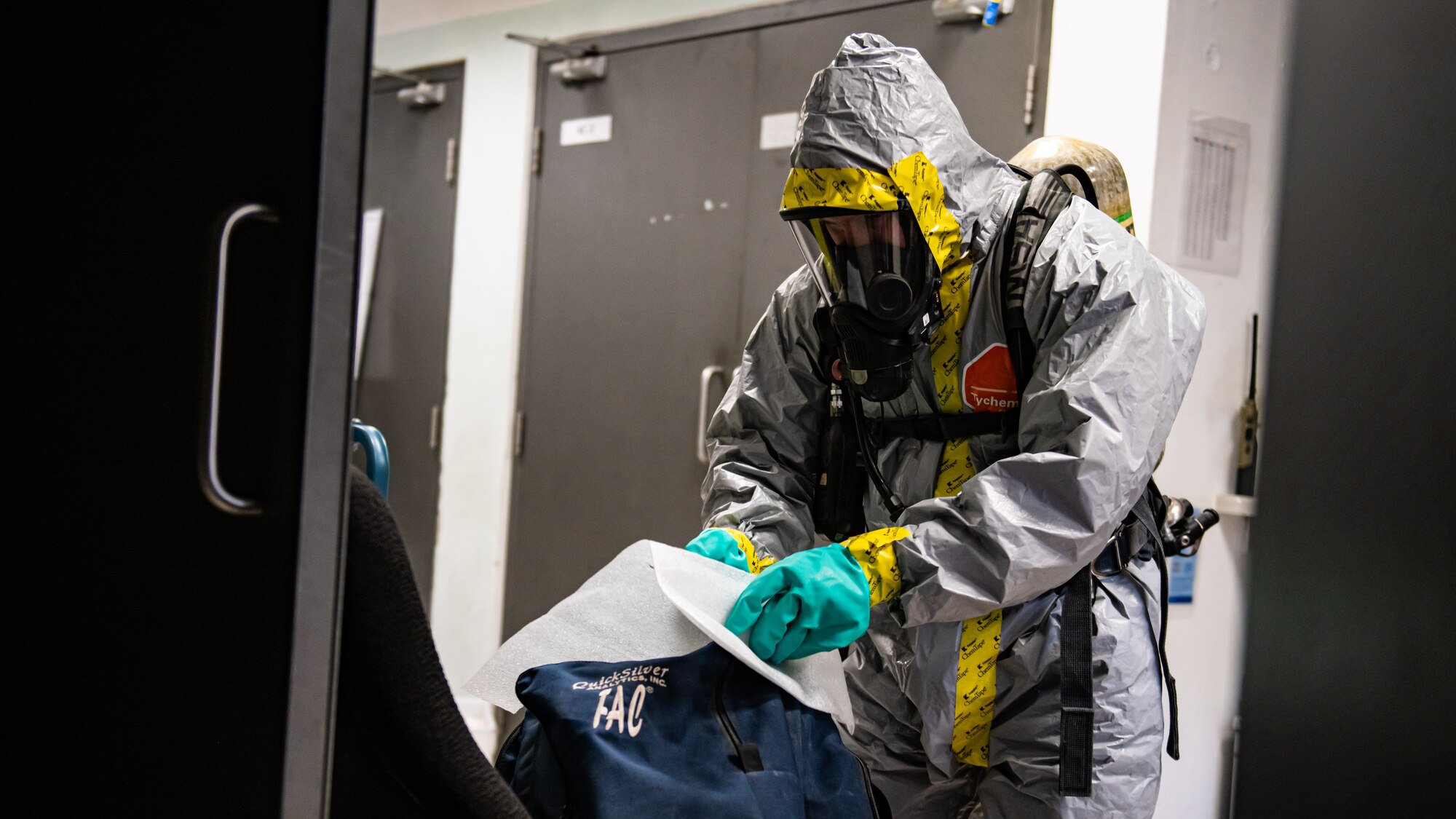 Airman retrieves gear from a bag.