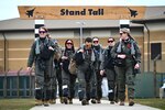 Pilots stride from the operations room to the flightline.