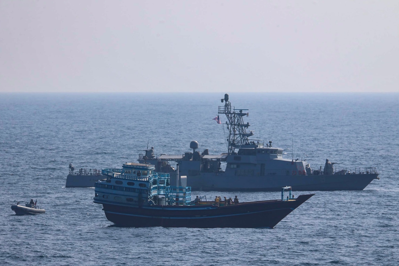 GULF OF OMAN (Jan. 18, 2022) U.S. service members conduct a boarding on a stateless fishing vessel transiting international waters the Gulf of Oman as a rigid-hull inflatable boat and patrol coastal ship USS Chinook (PC 9) sail nearby, Jan. 18. (U.S. Navy photo)