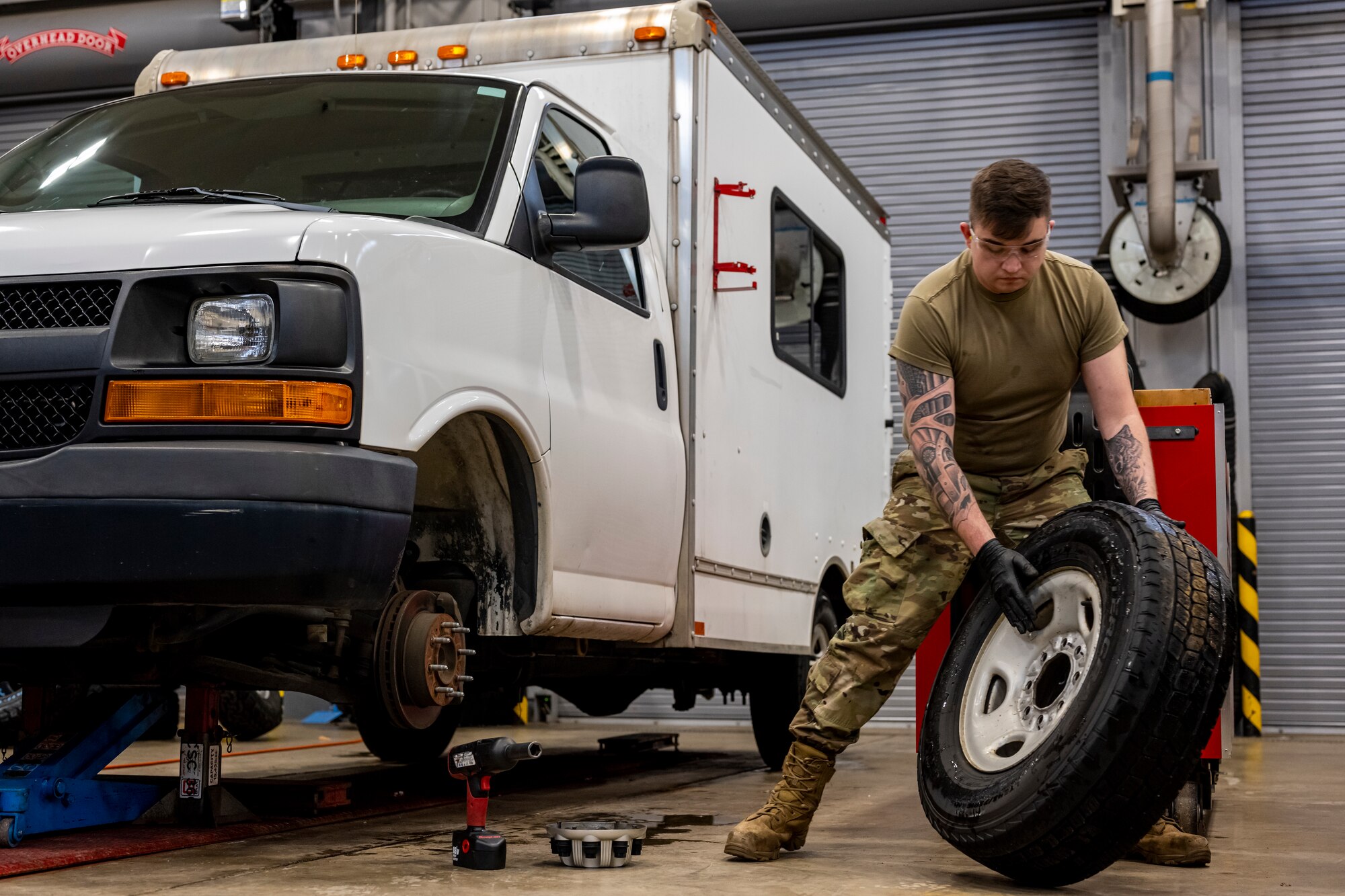Airman removing tire from a truck.