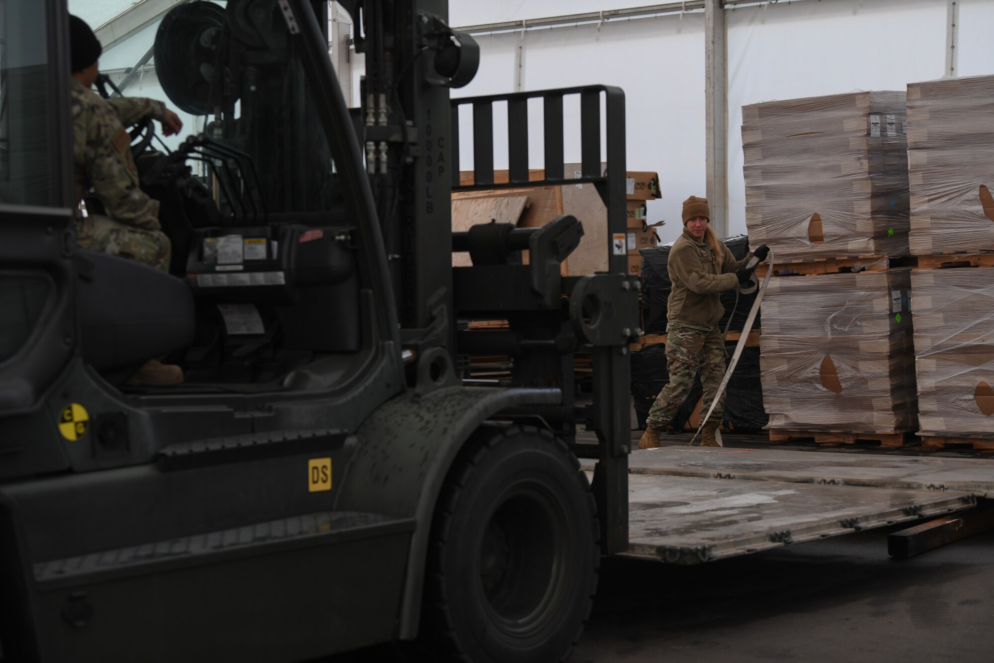U.S. Air Force Staff Sgt. Holly Gibbs, 435th Air Expeditionary Wing air transportation craftsman, unstraps pallets from a 10K Standard Forklift at Ramstein Air Base, Germany, Jan 21, 2022. During a flood, tents for U.S. and allied service members were damaged at Nigerien Air Base 101 and 201, which required replacements. The 435th AEW ensures Airmen have the resources to support counter-violent extremist operations in Africa and meet the demands of assigned missions.(U.S. Air Force photo by Senior Airman Ericka A. Woolever)