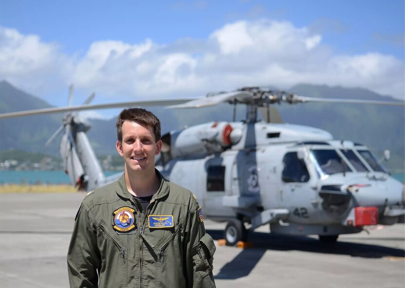 Navy pilot pictured in front of helicopter he flew for the service.