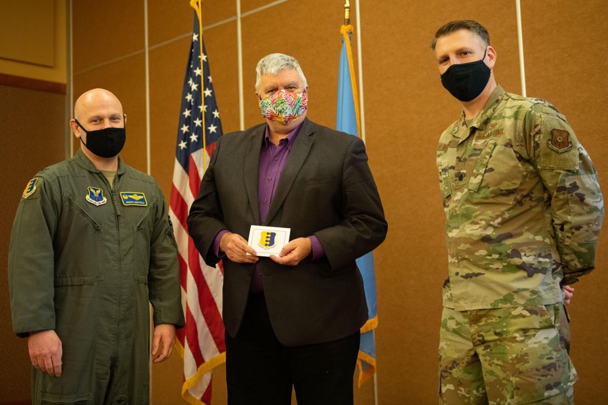 Col. Joseph Sheffield, 28th Bomb Wing commander (left), and Lt. Col. Samuel Miller, 28th Bomb Wing Judge Advocate (right), present Mark Vargo, Pennington County state’s attorney, with a lapel pin in recognition of being selected as the incoming honorary commander for the 28th BW/JA office during a special hail and farewell ceremony at The Monument Convention Center in Rapid City, S.D., Jan. 19, 2022.