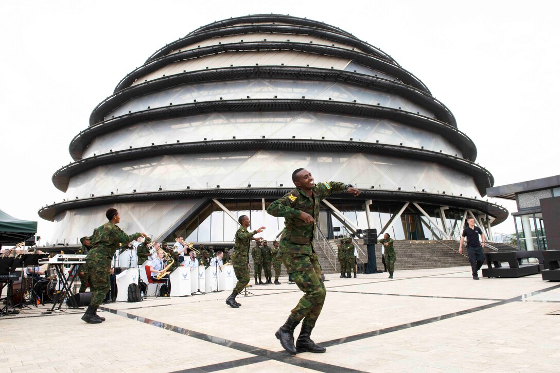 A group of people dance in front of a seated band.