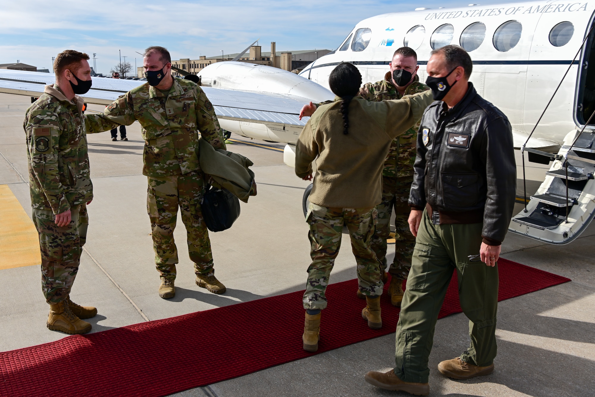 Maj. Gen. Thad Bibb, 18th Air Force commander, and Chief Master Sgt. Chad Bickley, 18th AF command chief, are greeted by Col. Nate Vogel, 22nd Air Refueling Wing commander, Chief Master Sgt. Melissa Royster, 22nd ARW command chief, and Maj. Rich Bielecki, 22nd ARW senior intelligence officer, upon their arrival Jan. 18, 2022, at McConnell Air Force Base, Kansas.