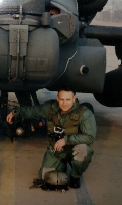 Man kneels next to helicopter