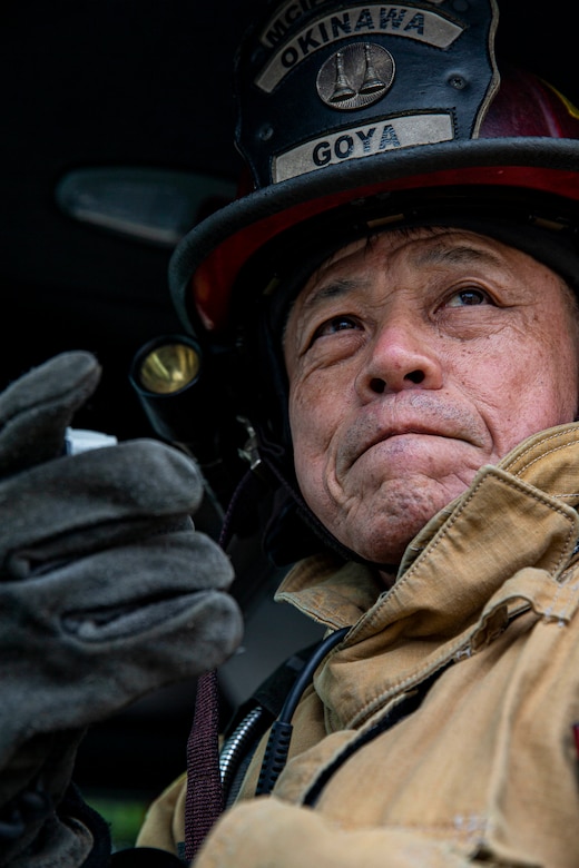A firefighter holds a communication device.