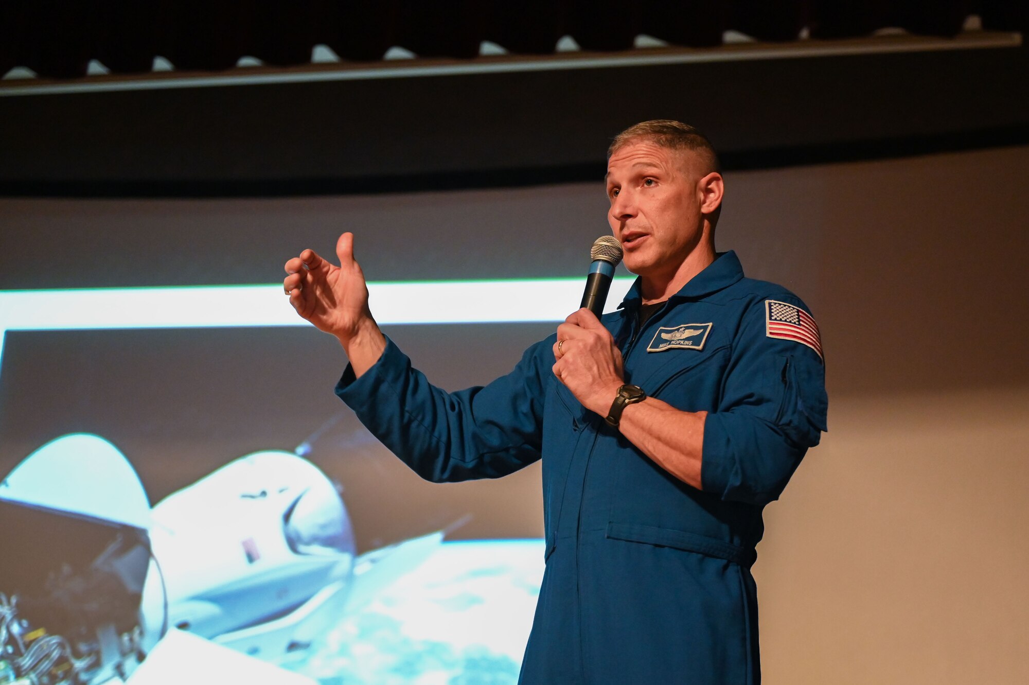 Man stands in front of NASA presentation.