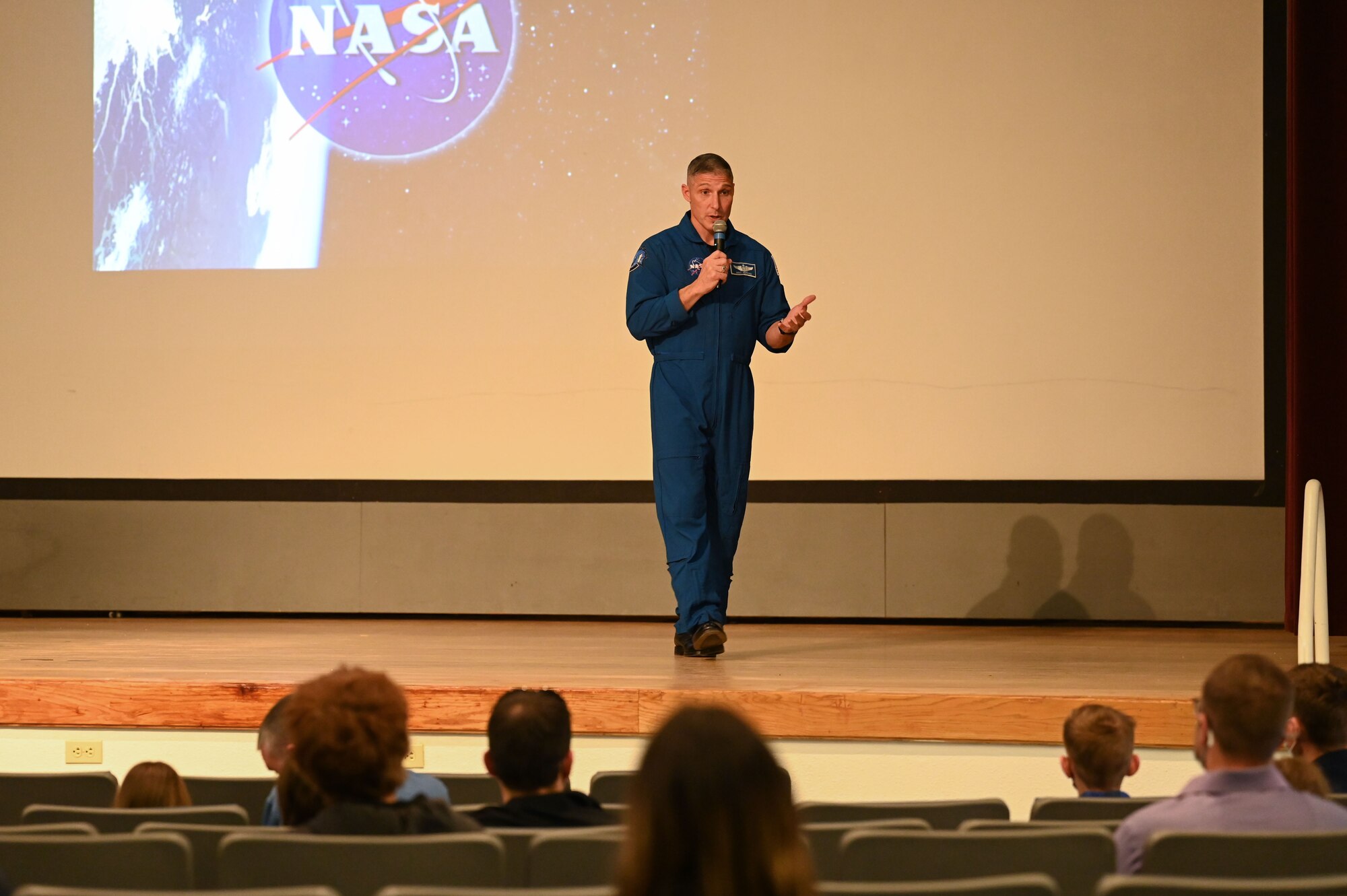 Man stands in front of NASA presentation.