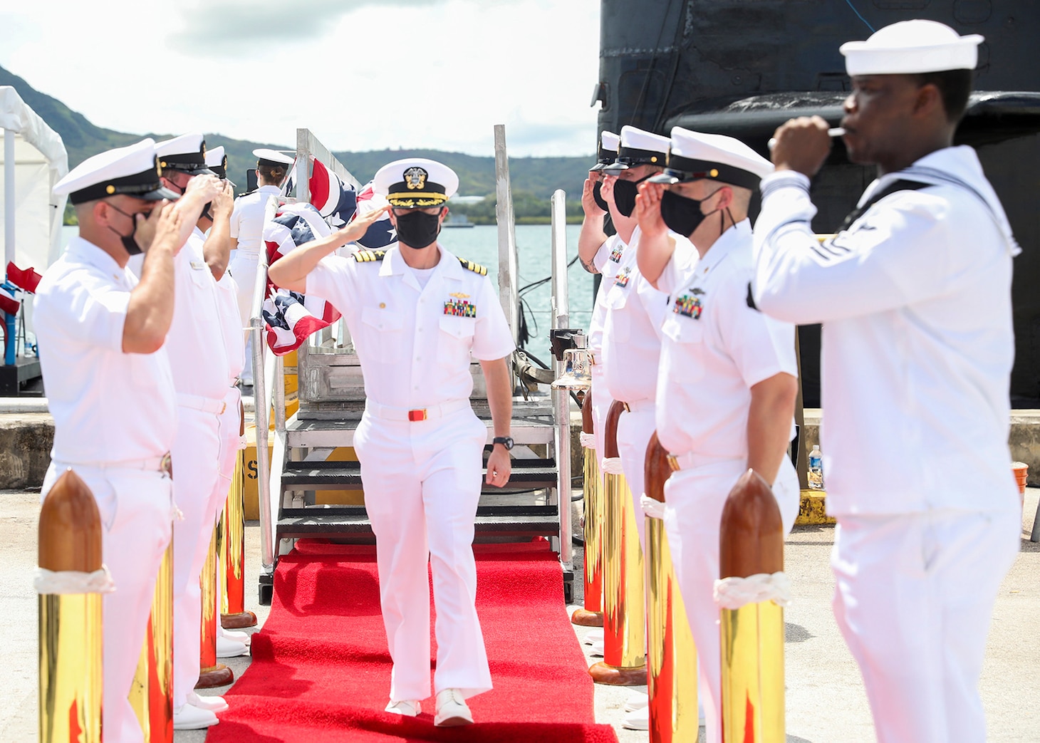NAVAL BASE GUAM (Sept. 3, 2021) Cmdr. Sean Welch, from Colonie, New York, passes through side boys during a change of command ceremony for the Los Angeles-class fast-attack submarine USS Oklahoma City (SSN 723), Sept. 3. Welch relieved Cmdr. Steven Lawrence, from Bridgeport, Pennsylvania, as Oklahoma City’s commanding officer during a ceremony held aboard the submarine. (U.S. Navy photo by Mass Communication Specialist 1st Class Jordyn Diomede)