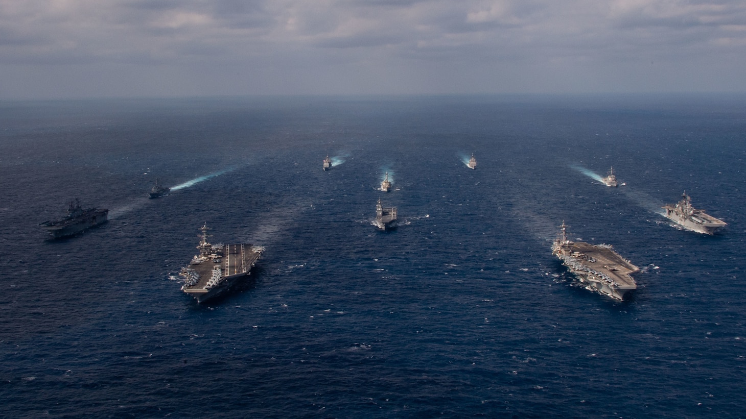 220122-N-PQ495-1384 PHILIPPINE SEA (Jan. 22, 2022) From left, Wasp-class landing helicopter dock USS Essex (LHD 2), Arleigh Burke-class guided-missile destroyer USS Gridley (DDG 101), Nimitz-class aircraft carrier USS Abraham Lincoln (CVN 72), Ticonderoga-class guided-missile cruiser USS Mobile Bay (CG 53), Arleigh Burke-class guided-missile destroyer USS Chafee (DDG 90), Japan Maritime Self-Defense Force (JMSDF) Hyuga-class helicopter destroyer JS Hyuga (DDH 181), Ticonderoga-class guided-missile cruiser USS Lake Champlain (CG 57), Nimitz-class aircraft carrier USS Carl Vinson (CVN 70), Arleigh Burke-class guided-missile destroyer USS Spruance (DDG 111) and America-class amphibious assault ship USS America (LHA 6) transit the Philippine Sea Jan. 22, 2022. Operating as part of U.S. Pacific Fleet, units assigned to Carl Vinson and Abraham Lincoln Carrier Strike Groups, Essex and America Amphibious Ready Groups and JMSDF are conducting training to preserve and protect a free and open Indo-Pacific region. (U.S. Navy photo by Mass Communication Specialist Seaman Larissa T. Dougherty)
