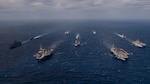 220122-N-PQ495-1384 PHILIPPINE SEA (Jan. 22, 2022) From left, Wasp-class landing helicopter dock USS Essex (LHD 2), Arleigh Burke-class guided-missile destroyer USS Gridley (DDG 101), Nimitz-class aircraft carrier USS Abraham Lincoln (CVN 72), Ticonderoga-class guided-missile cruiser USS Mobile Bay (CG 53), Arleigh Burke-class guided-missile destroyer USS Chafee (DDG 90), Japan Maritime Self-Defense Force (JMSDF) Hyuga-class helicopter destroyer JS Hyuga (DDH 181), Ticonderoga-class guided-missile cruiser USS Lake Champlain (CG 57), Nimitz-class aircraft carrier USS Carl Vinson (CVN 70), Arleigh Burke-class guided-missile destroyer USS Spruance (DDG 111) and America-class amphibious assault ship USS America (LHA 6) transit the Philippine Sea Jan. 22, 2022. Operating as part of U.S. Pacific Fleet, units assigned to Carl Vinson and Abraham Lincoln Carrier Strike Groups, Essex and America Amphibious Ready Groups and JMSDF are conducting training to preserve and protect a free and open Indo-Pacific region. (U.S. Navy photo by Mass Communication Specialist Seaman Larissa T. Dougherty)