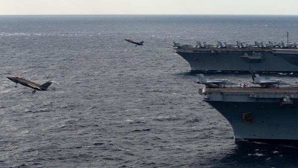 220122-N-PQ495-1208 PHILIPPINE SEA (Jan. 22, 2022) An F-35C Lightning II, assigned to the “Argonauts” of Strike Fighter Squadron (VFA) 147, launches off the flight deck of Nimitz-class aircraft carrier USS Carl Vinson (CVN 70) while an F-35C Lightning II, assigned to the “Black Knights” Marine Strike Fighter Squadron (VMFA) 314, launches off the flight deck of Nimitz-class aircraft carrier USS Abraham Lincoln (CVN 72) Jan. 22, 2022. Operating as part of U.S. Pacific Fleet, units assigned to Carl Vinson and Abraham Lincoln Carrier Strike Groups, Essex and America Amphibious Ready Groups and Japan Maritime Self-Defense Force, are conducting training to preserve and protect a free and open Indo-Pacific region. (U.S. Navy photo by Mass Communication Specialist Seaman Larissa T. Dougherty)