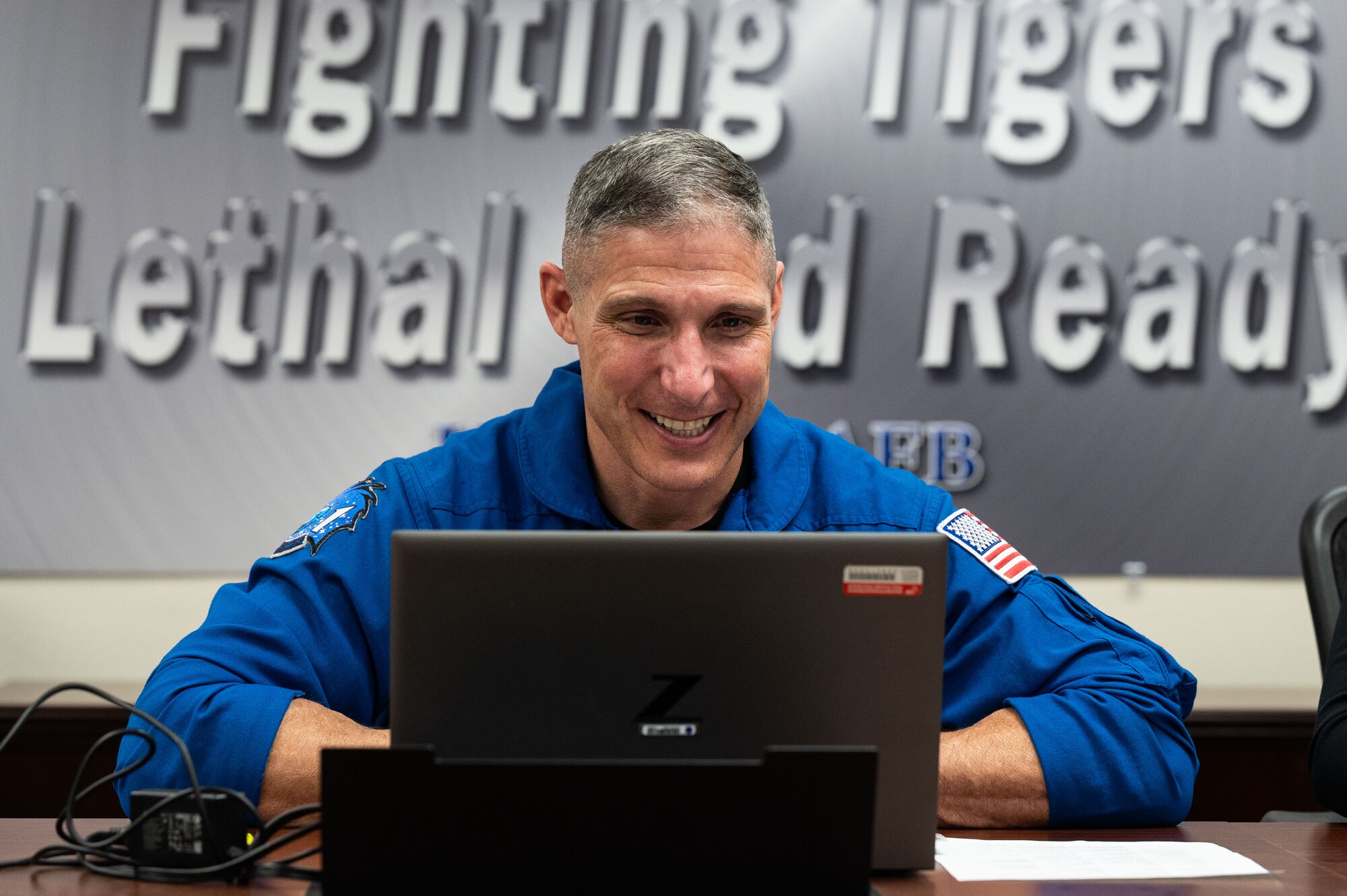 Man smiles at computer.