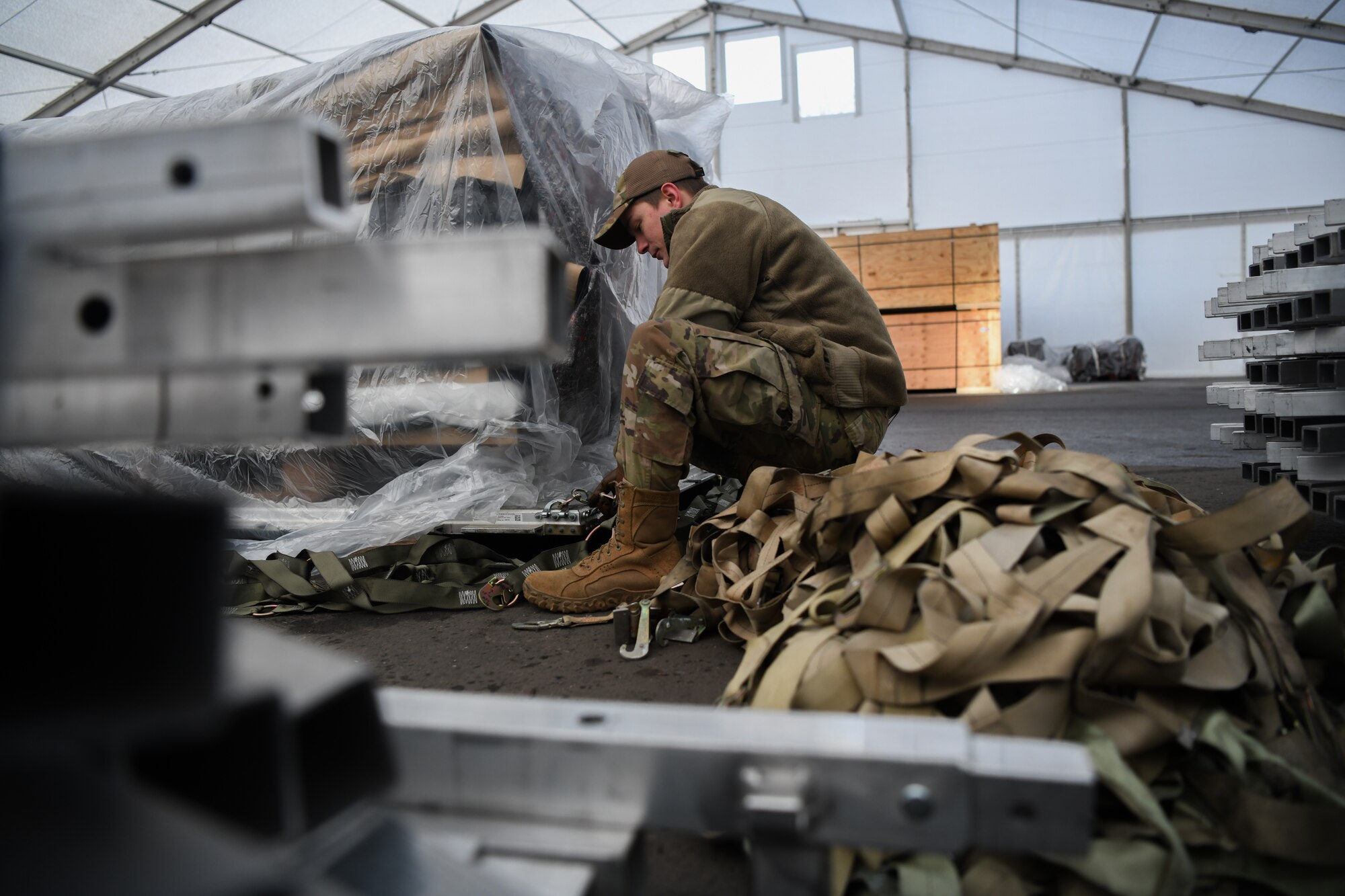 U.S. Air Force Staff Sgt. Kevin Taylor, 435th Air Expeditionary Wing air transportation craftsman, attaches nets to a pallet at Ramstein Air Base, Germany, Jan 21, 2022. During a flood, U.S. and allied service member tents were damaged at Nigerien Air Base 101 and 201, which required replacements. The 435th AEW ensures Airmen have the resources to support counter-violent extremist operations in Africa and meet the demands of assigned missions. The 435th AEW ensures Airmen have the forces and resources to demonstrate warfighting readiness. (U.S. Air Force photo by Senior Airman Ericka A. Woolever)
