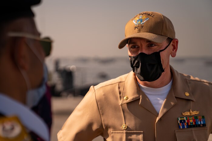 220125-N-N0146-1004 KARACHI, Pakistan (Jan. 25, 2022) Lt. Cmdr. Todd Strong, commanding officer of USS Squall (PC 7), speaks with a Pakistani officer after arriving in Karachi, Pakistan, for a scheduled port visit Jan. 25. Squall is currently operating in the Middle East region to help ensure maritime security and stability.