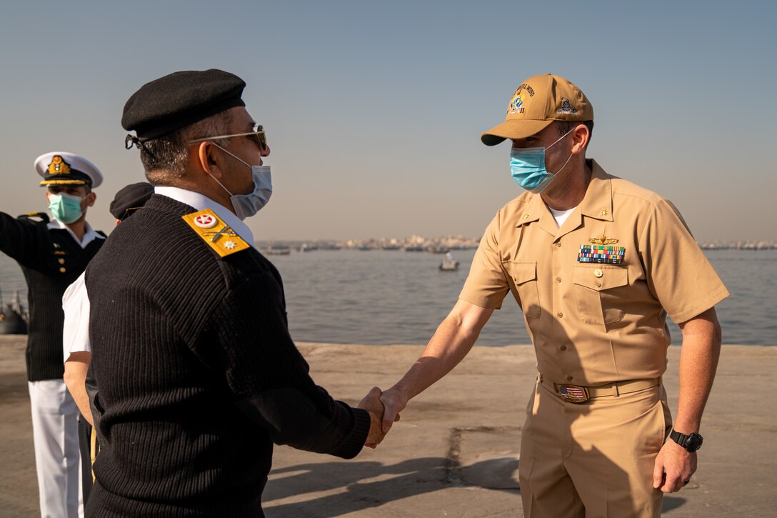 220125-N-N0146-1003 KARACHI, Pakistan (Jan. 25, 2022) Lt. Cmdr. Martin Dineen, commanding officer of USS Whirlwind (PC 11), greets a Pakistani officer after arriving in Karachi, Pakistan, for a scheduled port visit Jan. 25. Whirlwind is currently operating in the Middle East region to help ensure maritime security and stability.