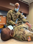 U.S. Air Force Staff Sgt. Kenneth Brown, 106th Rescue Wing, New York Air National Guard, demonstrates the proper way to check a patient during emergency medical technician training at the Farmingdale Armed Forces Reserve Center in Farmingdale, New York, Jan. 17, 2022.