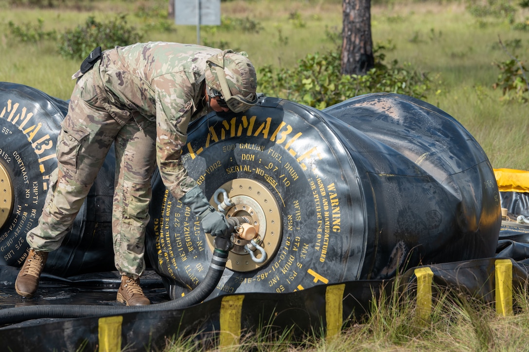 A soldier opens a valve on a nozzle.