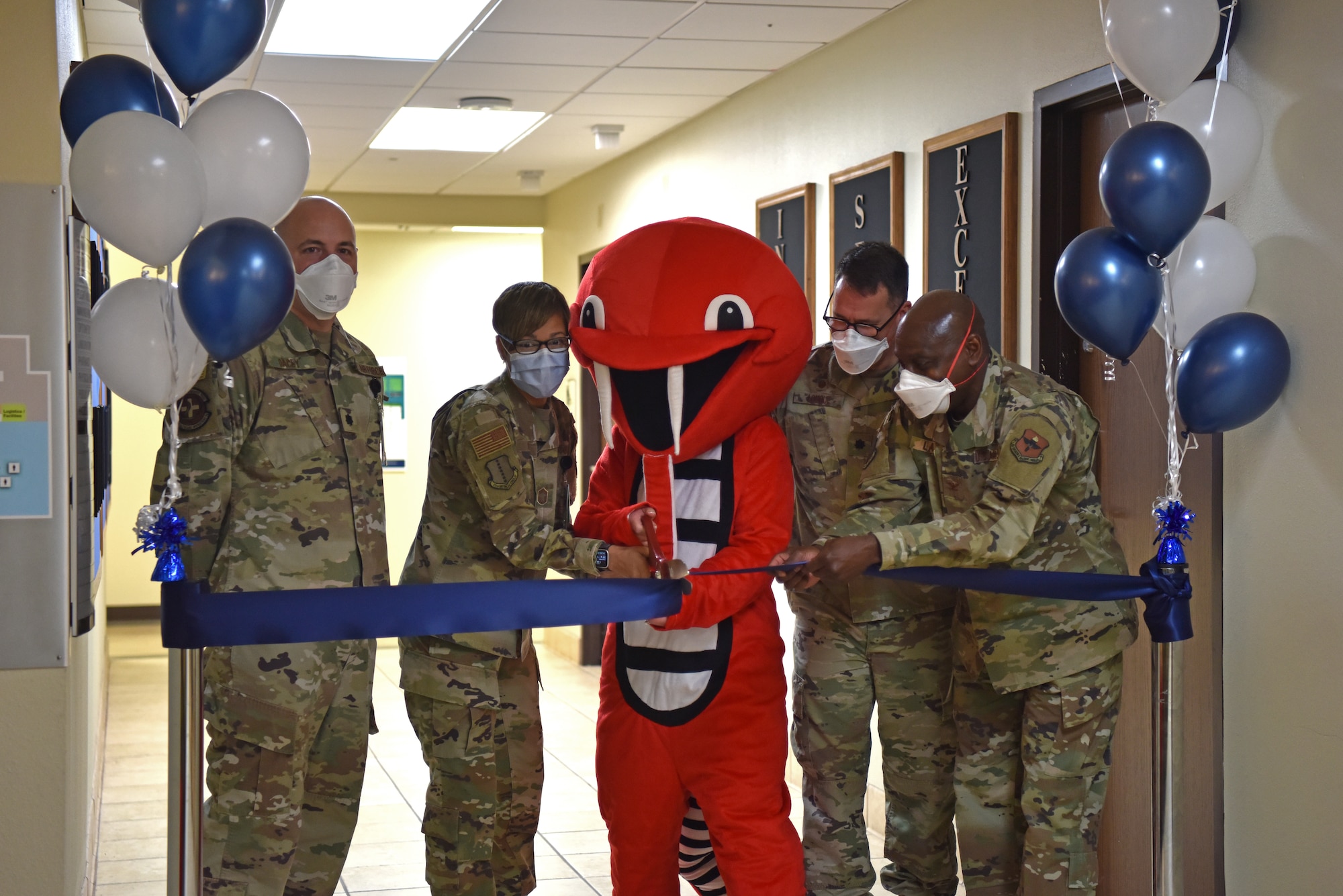 The 17th Medical Group leadership and cobra mascot cut the ribbon at the launch of MHS Genesis at the Ross Clinic, Jan. 24, 2022. Col. Derek Larbie, 17th Medical Group commander, and members of his leadership team gathered with Ross Clinic staff to celebrate the launch of MHS Genesis. (U.S. Air Force photo by Staff Sgt. Jermaine Ayers)