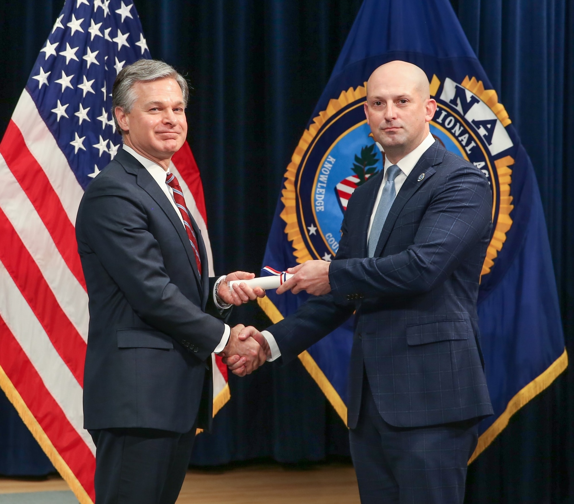 Federal Bureau of Investigation Director Christopher A. Wray, left, presents Office of Special Investigations Special Agent William Glidewell with his diploma Dec. 21, 2021, upon graduating the elite FBI National Academy, Quantico, Va. (FBI NA photo)