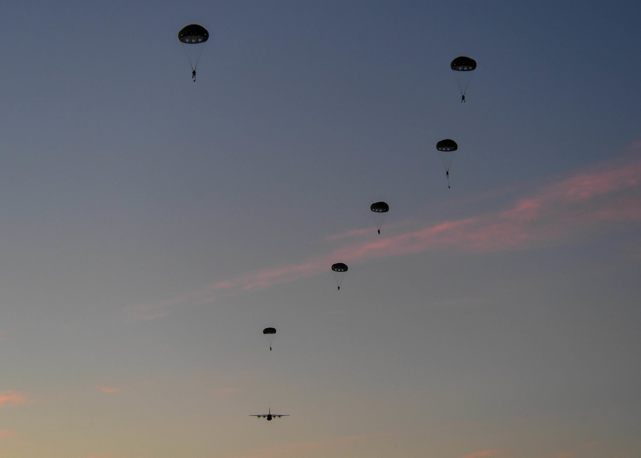 Airmen freefall while wearing parachutes.