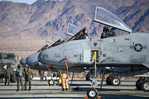 A photo of Airmen and Marines refueling an aircraft.