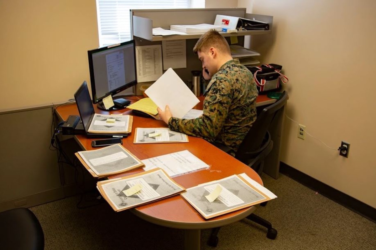A Marine attached to a tax center works with a customer over the telephone.